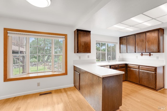 kitchen featuring sink, light hardwood / wood-style floors, and kitchen peninsula