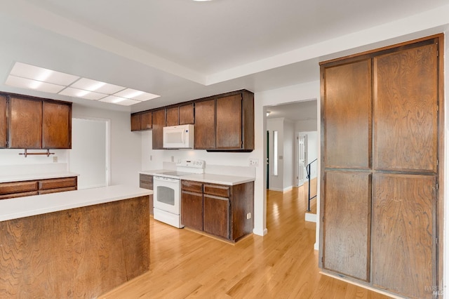 kitchen with white appliances and light wood-type flooring