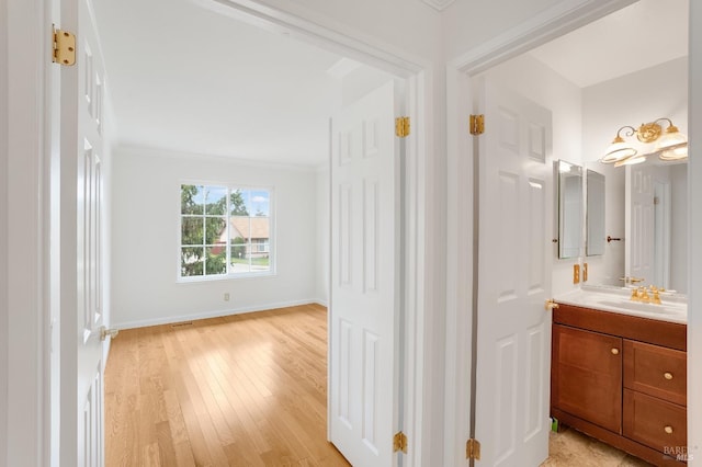 bathroom featuring ornamental molding, vanity, and hardwood / wood-style floors