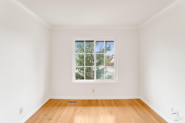 empty room with ornamental molding and light wood-type flooring