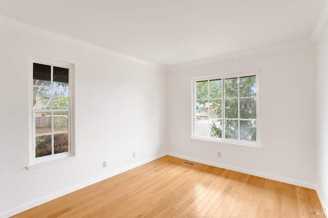 unfurnished room with crown molding, a healthy amount of sunlight, and light wood-type flooring