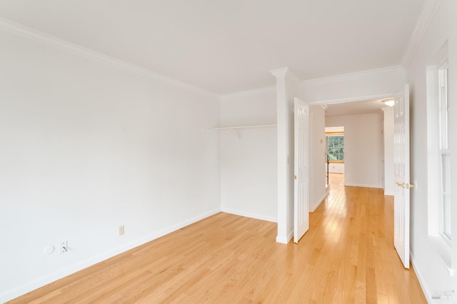 empty room featuring crown molding and light hardwood / wood-style flooring