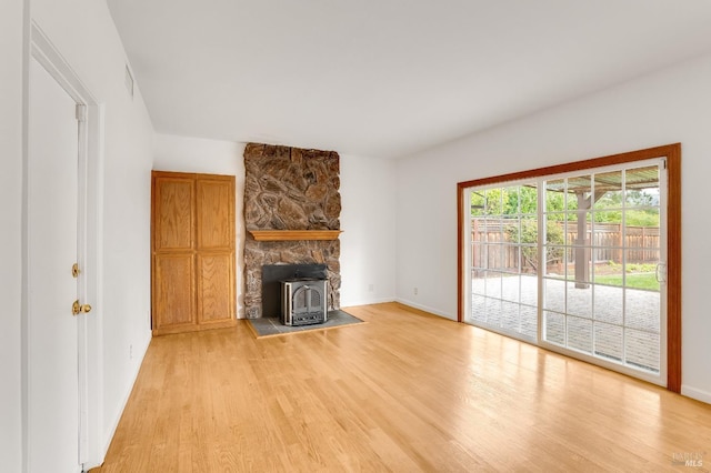 unfurnished living room with light hardwood / wood-style floors and a wood stove