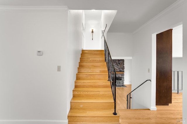 staircase featuring hardwood / wood-style flooring and ornamental molding