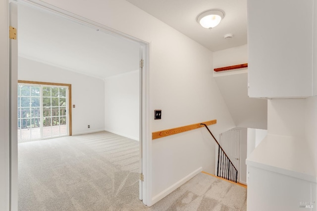 corridor featuring light colored carpet and vaulted ceiling