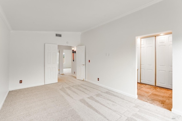 unfurnished bedroom with crown molding, light carpet, and a closet