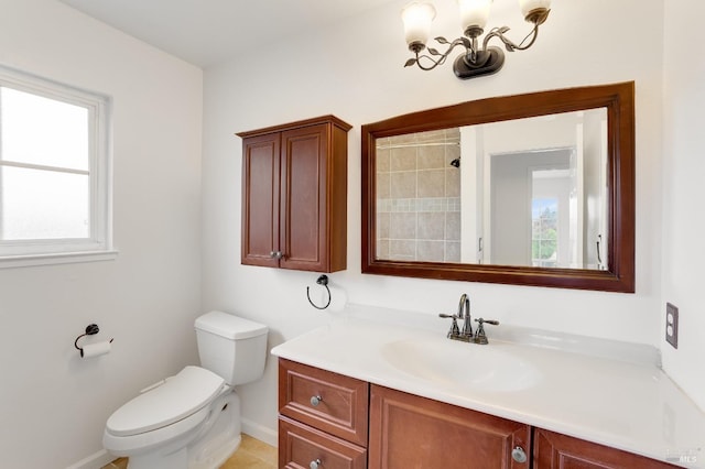 bathroom with vanity, toilet, and an inviting chandelier