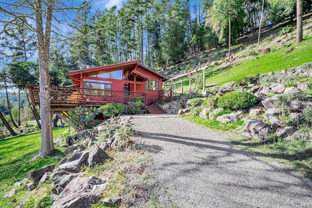 view of front of house with gravel driveway and a deck