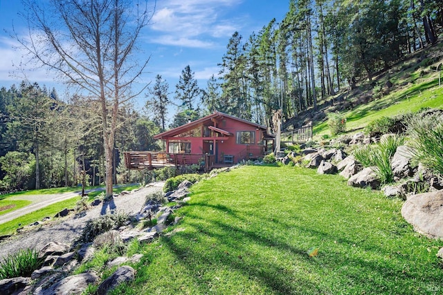 view of yard with driveway and a wooden deck