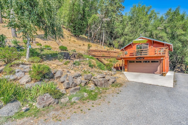 view of front of property featuring a garage, a deck, and driveway