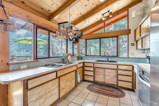 kitchen featuring light countertops, wood ceiling, tasteful backsplash, and a sink