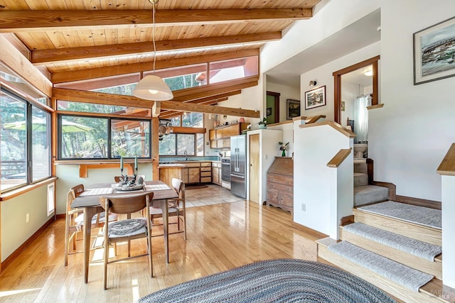 dining space featuring wood ceiling, sink, light hardwood / wood-style flooring, and vaulted ceiling with beams