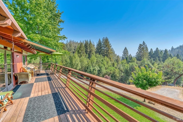 wooden terrace with a wooded view