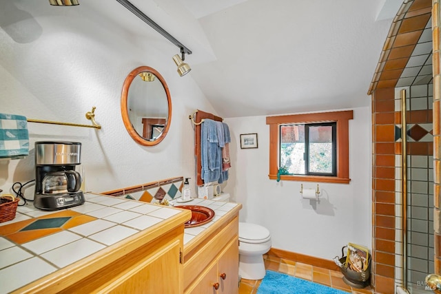 full bathroom featuring baseboards, lofted ceiling, toilet, and vanity