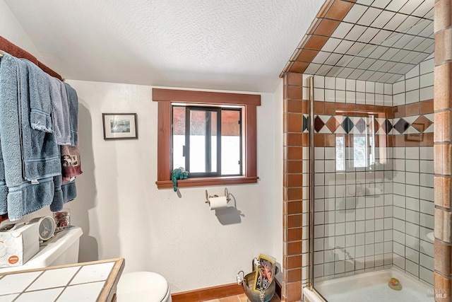 full bath featuring a stall shower, toilet, vanity, and a textured ceiling