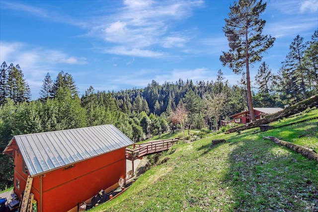 view of yard featuring an outbuilding and a wooded view