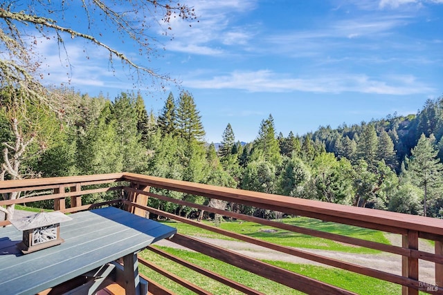 wooden terrace featuring a forest view