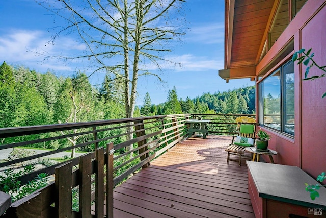 wooden terrace featuring a forest view