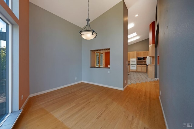 interior space featuring light hardwood / wood-style flooring and high vaulted ceiling