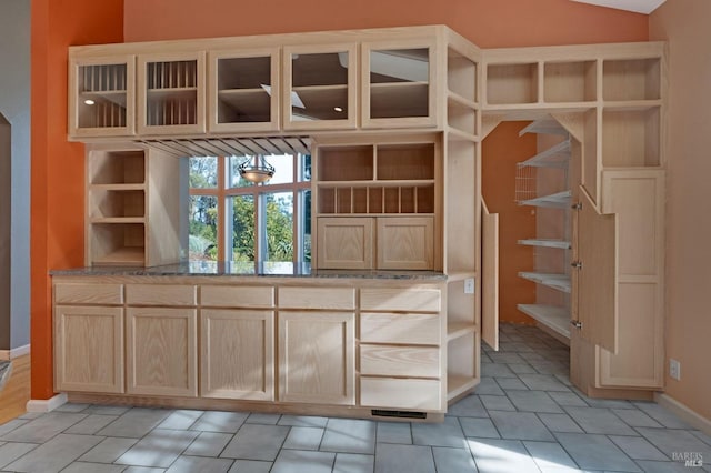 interior space featuring lofted ceiling, light brown cabinets, and a chandelier