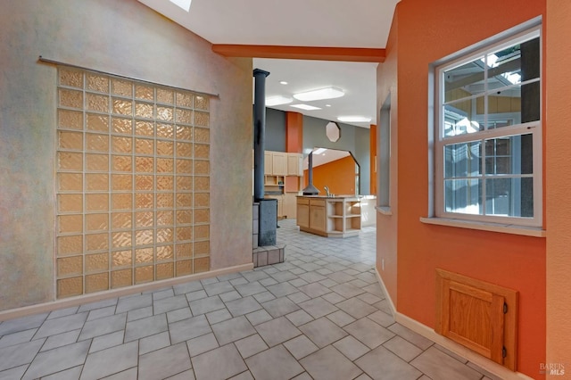 interior space featuring light tile patterned floors and beamed ceiling