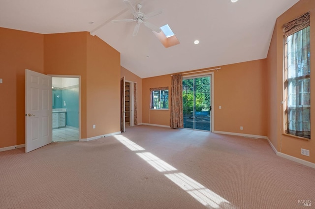 carpeted empty room with ceiling fan, a skylight, high vaulted ceiling, and beamed ceiling