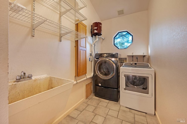 washroom featuring tile patterned flooring, sink, and separate washer and dryer