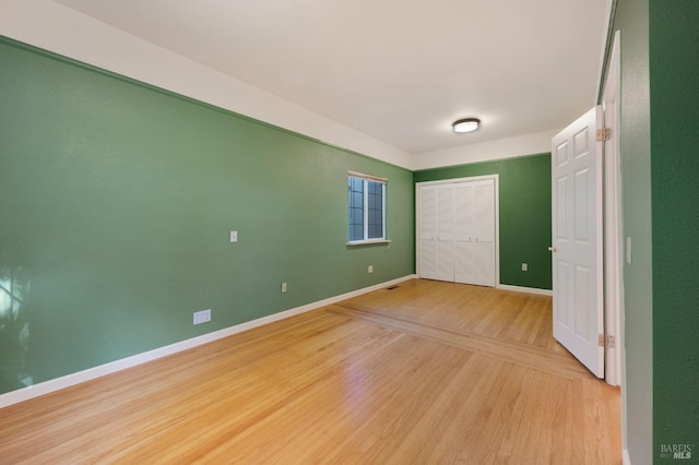 unfurnished bedroom featuring light wood-type flooring and a closet