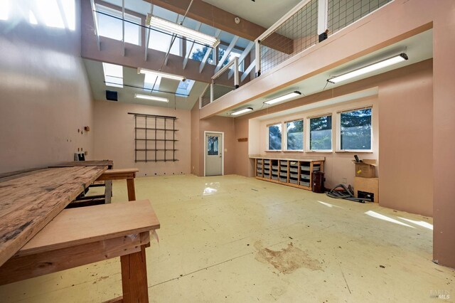 interior space with a high ceiling and concrete flooring