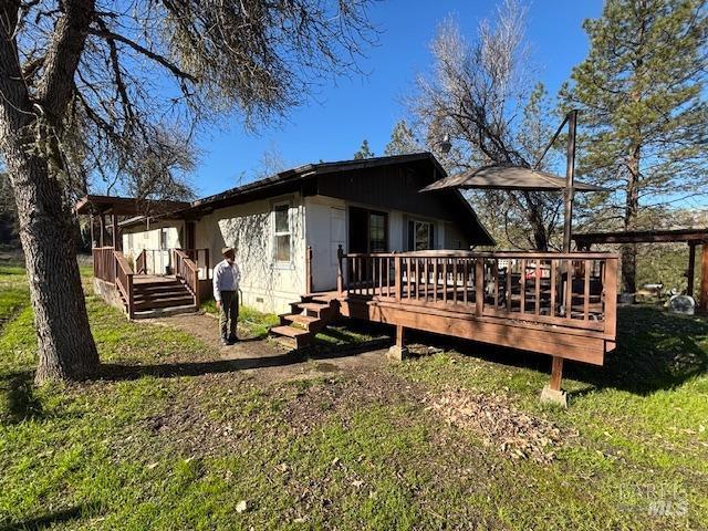 back of house featuring a yard and a deck