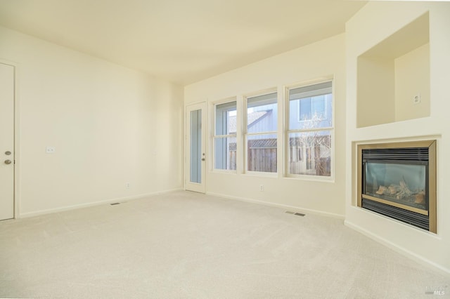 unfurnished living room with light colored carpet