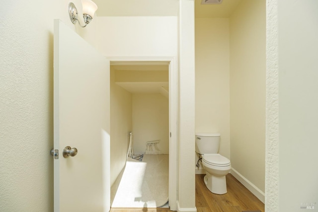 bathroom featuring toilet and wood-type flooring