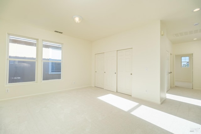 unfurnished bedroom with a closet and light carpet