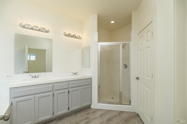 bathroom with vanity, wood-type flooring, and an enclosed shower