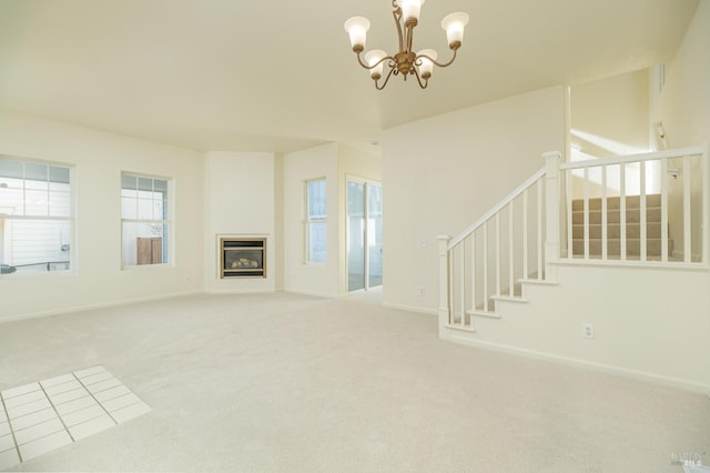 unfurnished living room featuring an inviting chandelier and carpet