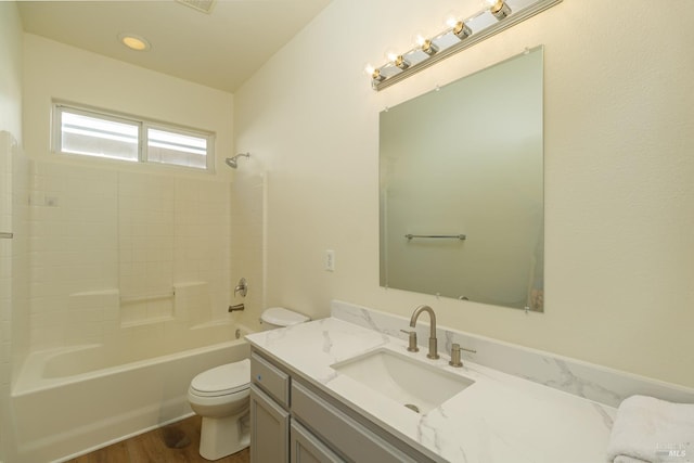 full bathroom featuring hardwood / wood-style flooring, shower / tub combination, toilet, and vanity