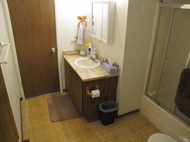 bathroom with vanity and shower / bath combination with glass door