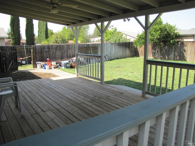 wooden deck featuring ceiling fan and a yard