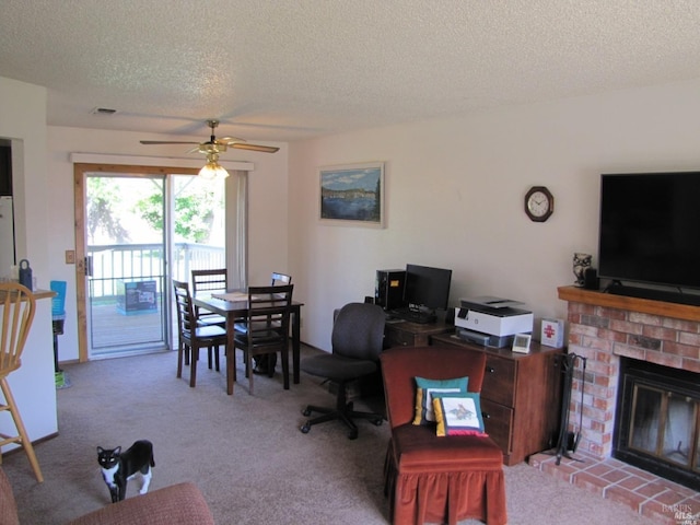 carpeted office with ceiling fan, a fireplace, and a textured ceiling