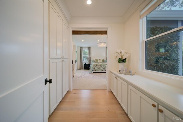 kitchen with built in refrigerator, premium range hood, white cabinets, and a kitchen island with sink