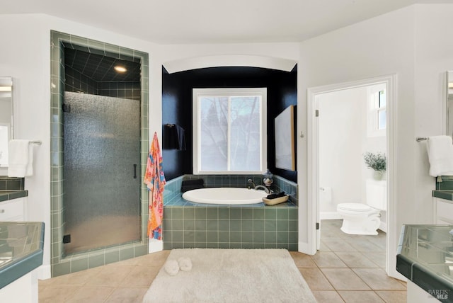 bathroom with toilet, tile patterned flooring, plenty of natural light, and separate shower and tub