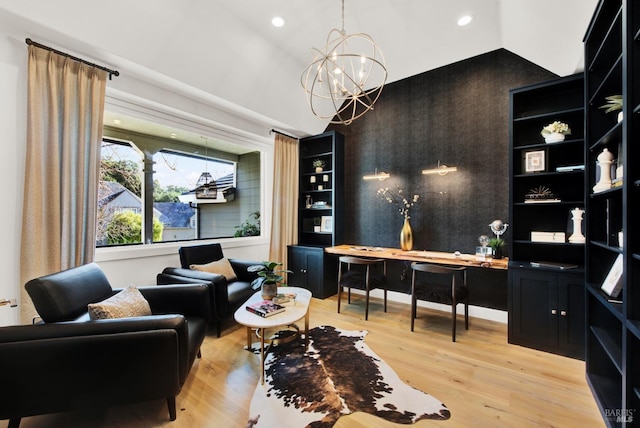 home office with light hardwood / wood-style flooring, a chandelier, and vaulted ceiling