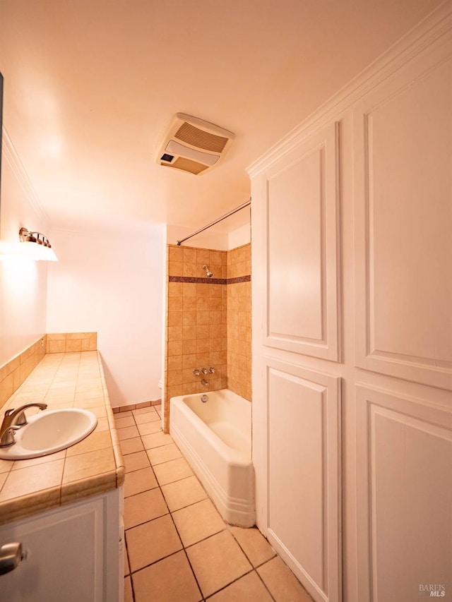 bathroom featuring vanity, tile patterned flooring, tiled shower / bath combo, and crown molding