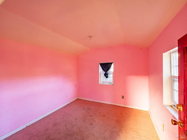 carpeted spare room with lofted ceiling