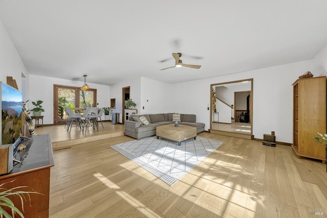 living room featuring ceiling fan and light hardwood / wood-style flooring