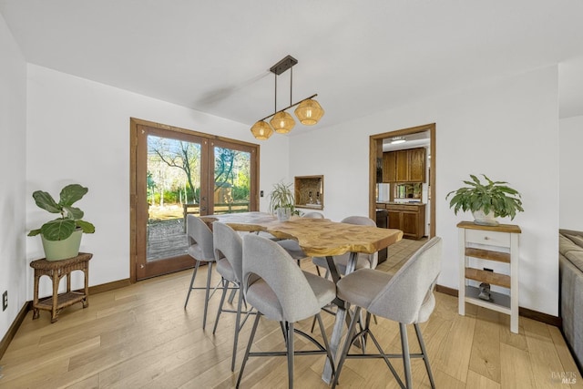 dining space featuring light wood-type flooring and french doors