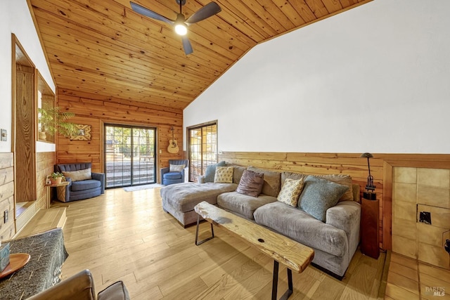 living room featuring wood ceiling, wooden walls, high vaulted ceiling, light wood-type flooring, and ceiling fan