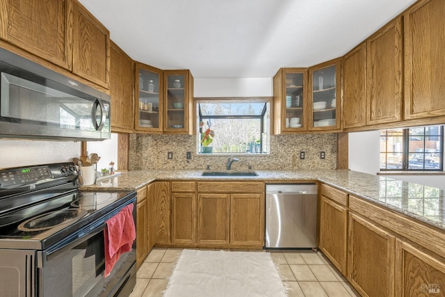 kitchen featuring light tile patterned floors, sink, black / electric stove, and dishwasher