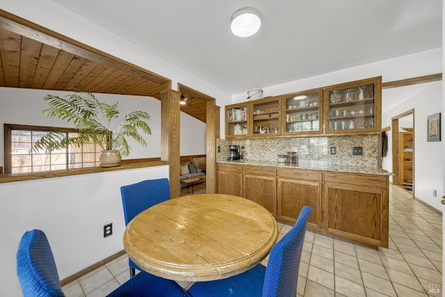 tiled dining area featuring wooden ceiling, indoor bar, and vaulted ceiling