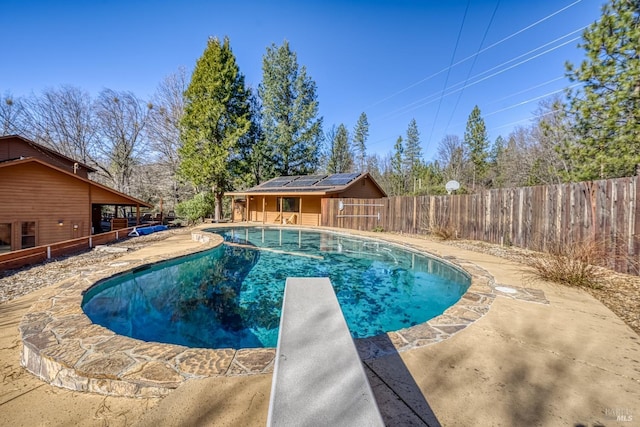 view of swimming pool with a diving board